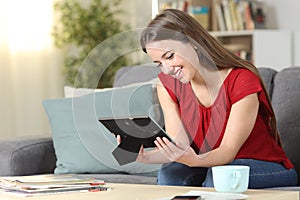 Happy woman remembering looking at photo frame photo