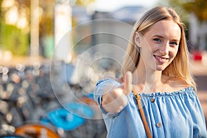 happy woman renting bicycle at public urban cycle station