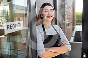 happy woman with reopen banner on door glass