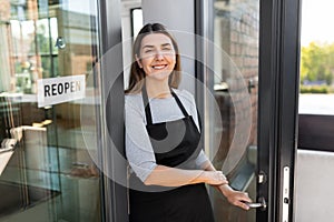 happy woman with reopen banner on door glass