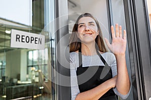 happy woman with reopen banner to door glass