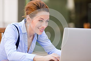 Happy woman resting hands on keyboard, looking on computer laptop screen