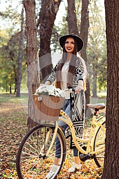 Happy woman riding bike bicycle in fall autumn park