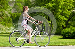 Happy woman riding fixie bicycle in summer park