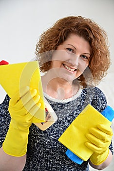 Happy woman in rubber gloves with cleaning agents