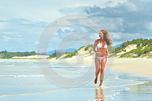 Happy woman running along the beach