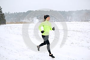 Happy woman running along snow covered winter road