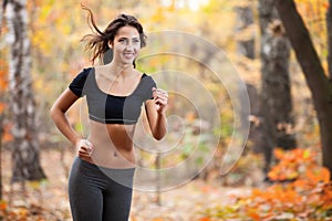 Happy woman running in autumn forest