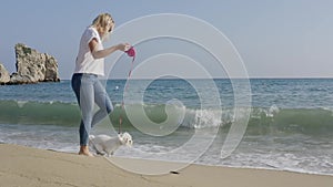 Happy woman running with dog at the beach.