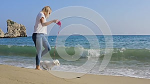 Happy woman running with dog at the beach