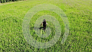 Happy woman running by green field, happiness freedom inspirational concept, shot from drone above top