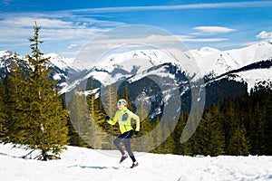 Happy woman running in mountains on winter snow