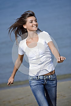 Happy woman running windblown on the beach