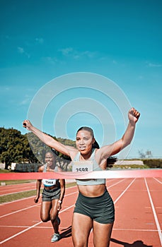 Happy woman, running and winning by finish line in race, competition or marathon on outdoor stadium track. Female person