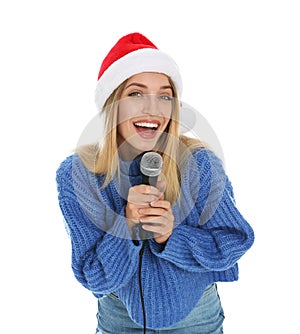 Happy woman in Santa Claus hat singing with microphone on white background. Christmas music