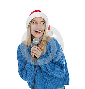 Happy woman in Santa Claus hat singing with microphone on white background. Christmas music