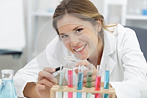 happy woman scientist with pipettes in lab photo