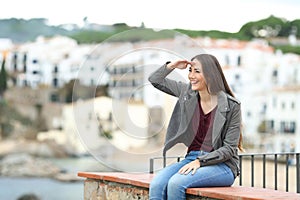 Happy woman scouting on a ledge on vacation