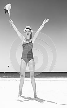 Happy woman on seashore with windmill toy rejoicing