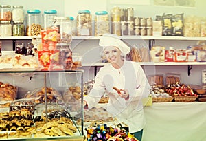 Happy woman seller offering sweets