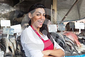 Happy woman selling fresh fish on a latin fish market