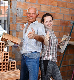 Happy woman and senior man in repairable house