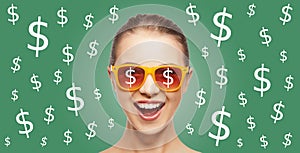 Happy woman in shades with dollar currency sings