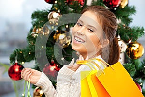 Happy woman with shopping bags and christmas tree