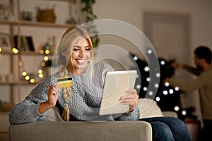 Happy woman shopping online on Christmas, using digital tablet