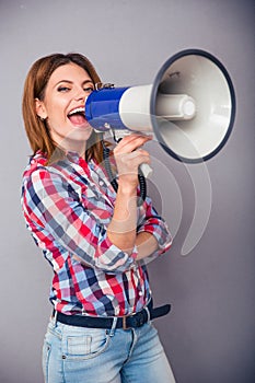 Happy woman shouting in megaphone