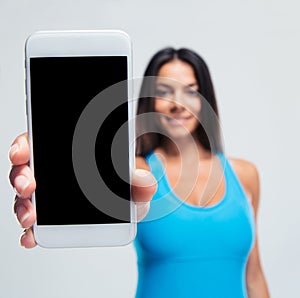 Happy woman showing blank smartphone screen