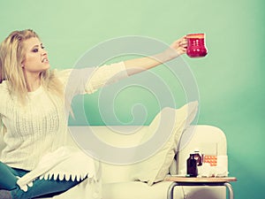 Happy woman showing cup of tea