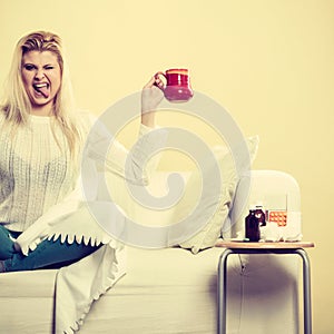 Happy woman showing cup of tea