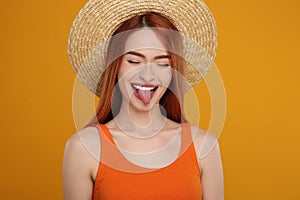 Happy woman showing her tongue on orange background