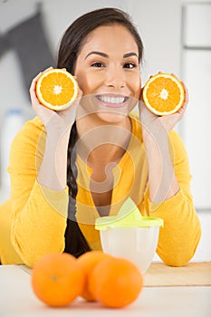 happy woman showing oranges to camera