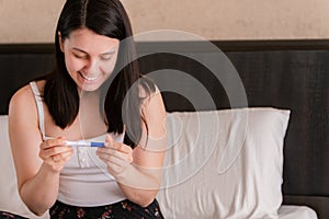 happy woman showing positive pregnancy test