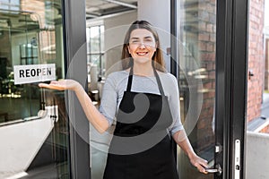 happy woman showing reopen banner on door glass