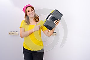 Happy woman showing thumbs up with a box of tools in her hands, copy space