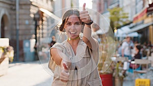 Happy woman showing thumbs up, like sign positive something good positive feedback in city street