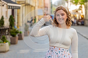 Happy woman showing thumbs up like sign positive something good positive feedback in city street