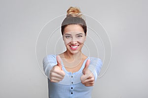 Happy woman showing thumbs up and smiling at camera