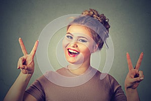 Happy woman showing victory or peace sign gesture