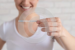 Happy woman shows a negative ovulation test. The concept of female fertility and luteinizing hormone. Not the right time