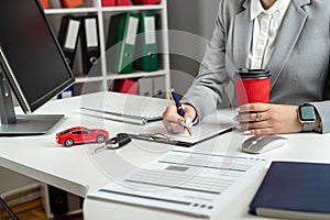 Happy woman signs a contract loan agreement, purchase new car or rent vechicle at office