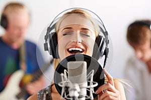 Happy woman, singer and microphone with headphones in music recording studio, sound track or podcast. Female person