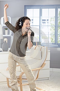 Happy woman singing with headphones