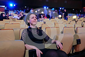Happy woman sits in auditorium in tv studio of photo