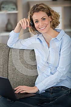 happy woman sitting on couch in living room photo