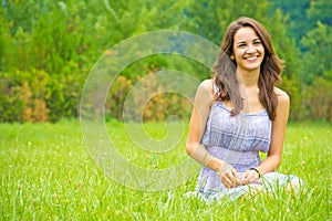 Happy woman sitting on grass