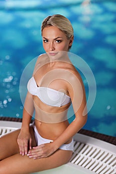 Happy woman sitting in jacuzzi at poolside